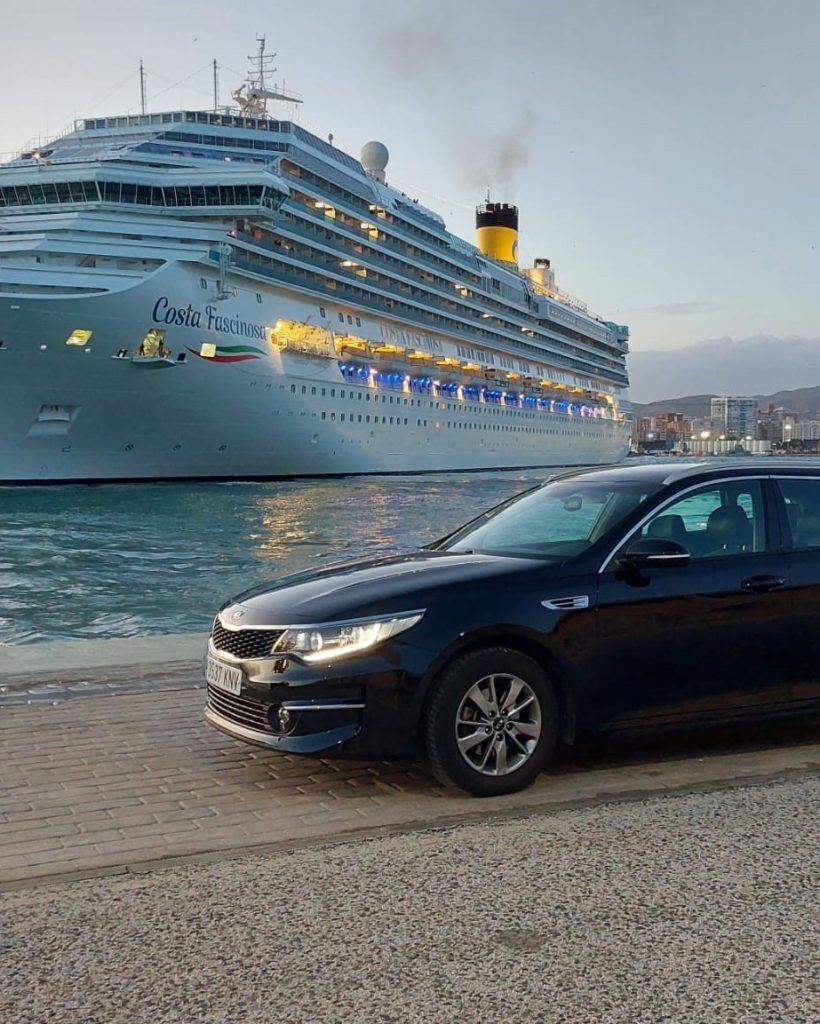 Coche de empresa de transportes de confianza en Málaga junto a un crucero en el puerto